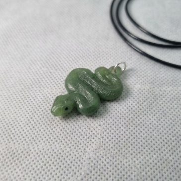 Exquisite pendant handcrafted from natural green jade. This elegant serpent design symbolizes wisdom and renewal, making it a ti…