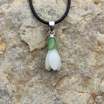 This elegant Snowdrop Pendant features a stunning contrast of white and green nephrite jade. A delicate floral design that captu…
