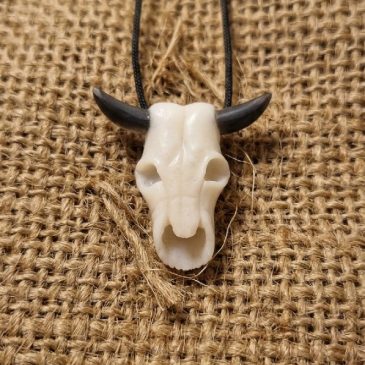 Handcrafted pendant featuring a white jade bull skull with sleek obsidian horns. A bold, minimalist accessory blending natural t…