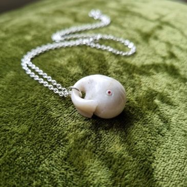 White jade Moby Dick pendant with faceted stone eyes. A minimalist masterpiece of oceanic grace.
