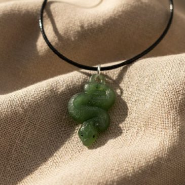 This handcrafted nephrite jade snake pendant features deep green tones and vibrant red garnet eyes. A timeless piece of jewelry …