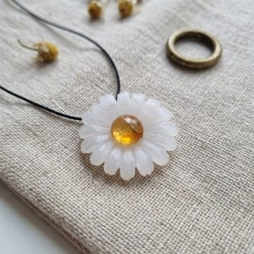 A delicate, handcrafted white jade daisy pendant, featuring a vibrant carnelian heart. #handcraftedjewelry #whitejade #daisypend…