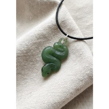 Adorned with deep red garnet eyes, this hand-carved nephrite jade snake pendant embodies timeless elegance and sleek artistry. A…