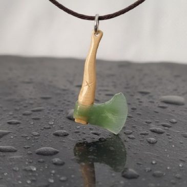 This handcrafted Axe Pendant features a striking contrast between deep green Nephrite and the earthy tones of Petrified Wood. A …