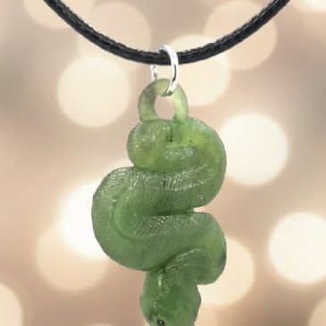 This exquisite nephrite snake pendant features a sleek, coiled design meticulously carved from deep green jade. Its piercing eye…