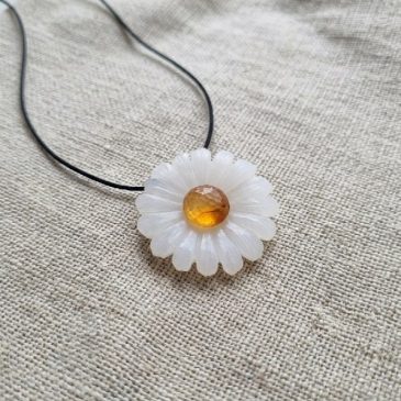 Charming white jade daisy pendant. Features a genuine carnelian stone at its center for a splash of color. Hand-carved and elega…